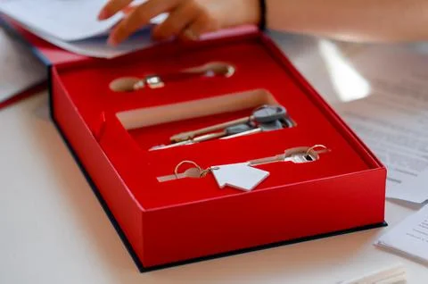 Key set in red box with paperwork on table, real estate concept Stock Photos
