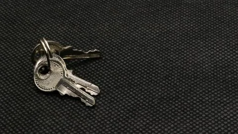 The key is silver with a black background. Stock Photos