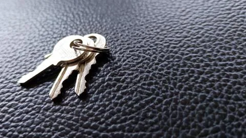 The key is silver with a black background. Stock Photos