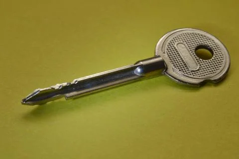 The key is silver on a yellow background. Stock Photos