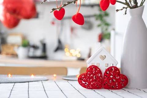 Key to tiny house of cozy home with Valentine decor on table of kitchen. Gi.. Stock Photos