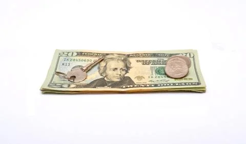 Key on top of dollar bills and coins Stock Photos