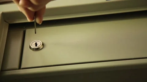 Key unlocked a safe latch and opening door safety deposit box. man folds Stock Footage 65414890