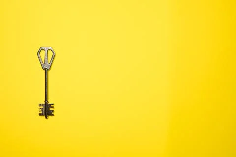 Key on yellow background. Minimal creative style Stock Photos