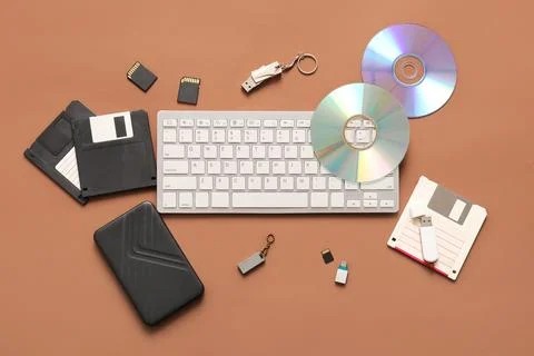 Keyboard and different memory storage devices on brown background Stock Photos