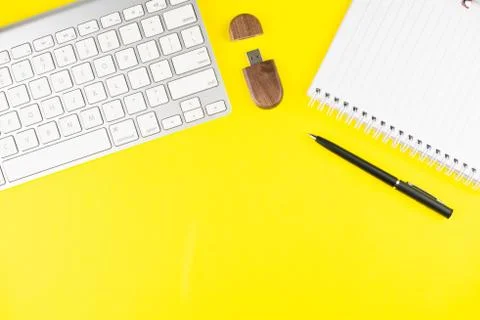 Keyboard, black pen, notepad planner and wooden USB flash on yellow backgroun Stock Photos