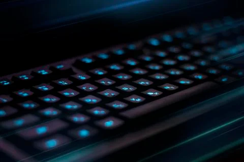 Keyboard with blue backlight on table. rays of blue light Stock Photos