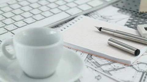 Keyboard, cup, notepad, pen and architectural drawings Stock Footage 644064