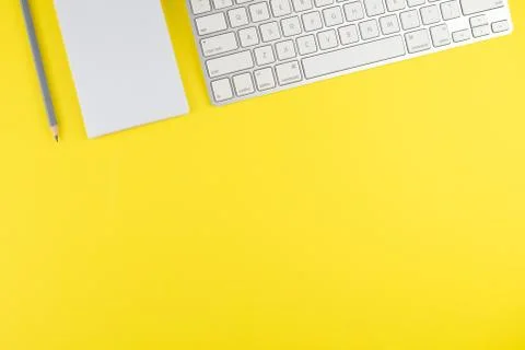 Keyboard notepad planner with gray pencil on yellow background. Flat lay. Cop Stock Photos