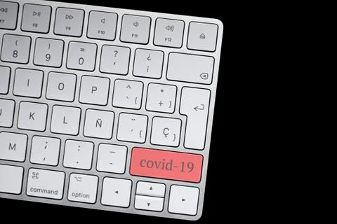 Keyboard with the red covid-19 button. On a black background with space for t Stock Photos