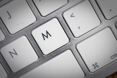 Keyboard - silver portable computer keyboard in IT department with letter M i Stock Photos