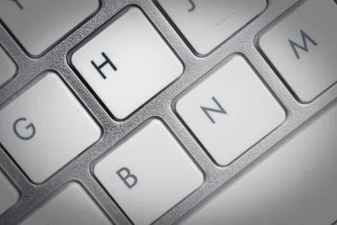 Keyboard - silver portable computer keyboard in IT department with letter H i Stock Photos