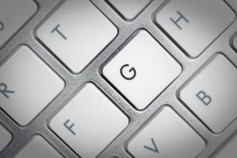 Keyboard - silver portable computer keyboard in IT department with letter G i Stock Photos