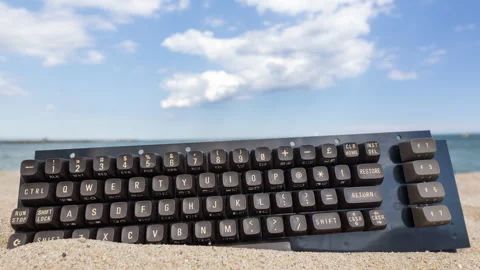 Keyboard stcuk in sand on beach 스톡 동영상 276332825