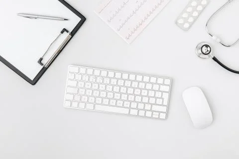 Keyboard surrounded by paper in folder, computer mouse, stethoscope isolated  Stock Photos