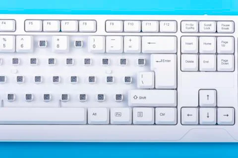 Keyboard without some keys. White keyboard on blue background. Top view.  Foto stock