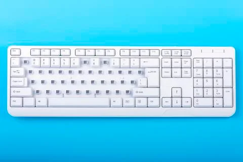 Keyboard without some keys. White keyboard on blue background. Top view.  Stock Photos