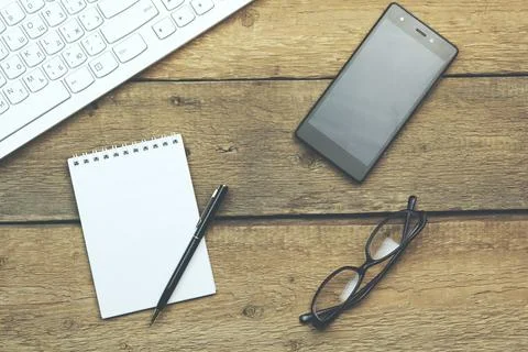 Keyboard,notebook and phone on table Stock Photos