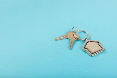 Keychain in the shape of a house with a key ring on background. 스톡 사진
