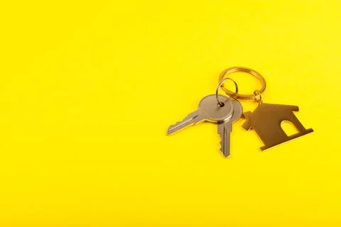 Keychain in the shape of a house with a key ring on background. 스톡 사진