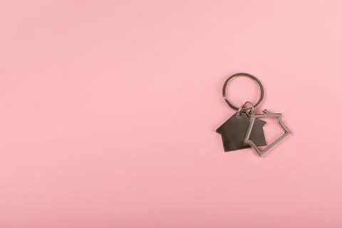 Keychain in the shape of a house with a key ring on background. 스톡 사진