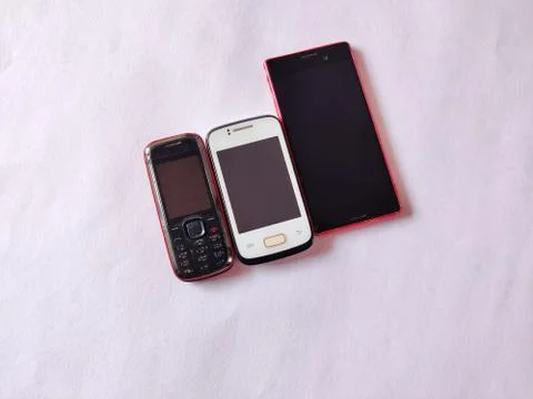 Keypad mobile and two smart phones in different sizes isolated on white backg Stock Photos