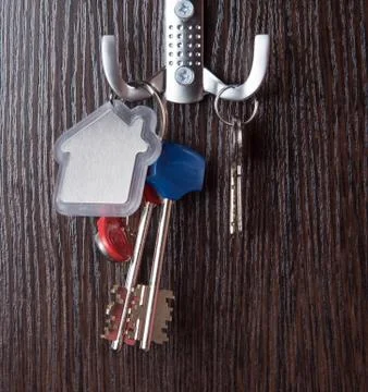 Keys and House shaped keychain on wooden background Stock Photos