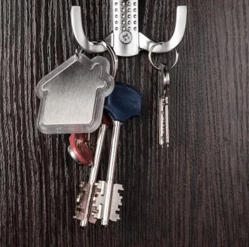 Keys and House shaped keychain on wooden background Stock Photos