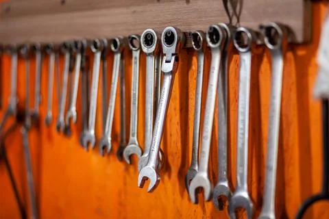Keys and work tools hang on the wall in a car repair shop or garage. Stock Photos
