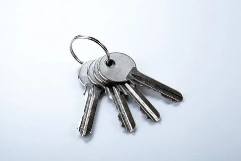 Keys from the apartment on a white table Stock Photos