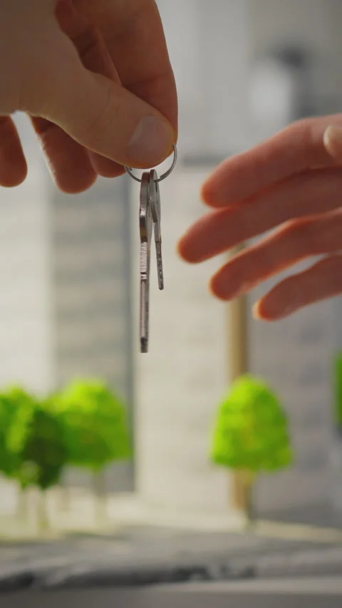 Keys exchanged in a model city as part of a real estate transaction process Stock Footage 331601832