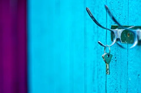 Keys hanging from a hook on the old painted wooden wall outside Stock Photos