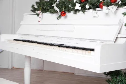 Keys on white upright piano with christmas decor Stock Photos