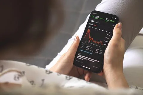 Kharkov, Ukraine - August 25, 2021: Woman using Apple Stock market charts app Stock Photos