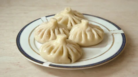 Khinkali is placed on a plate. preparation for dinner, Georgian cuisine Stock Footage 201891776