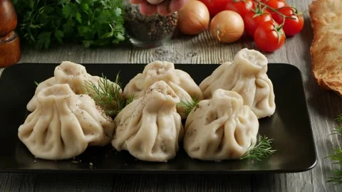 Khinkali served on a platter. Presentation of the dish. The cook sprinkles th Stock Footage 147870656