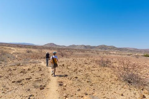 Khorixas, Namibia - August 26, 2016: Tourist and guide walking in the famous  Stock Photos
