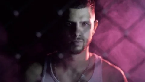 Kickboxer comes out of the shadows. Face close-up behind the grid. dark room Stock Footage 80862186