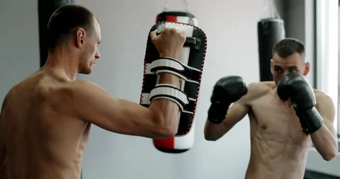 Kickboxer does roundhouse kick in slow motion, kickboxers are training in the Stock Footage 160145344