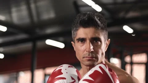 Kickboxer looking confident at camera tough male kickboxer wearing boxing gloves Video stock 201405265