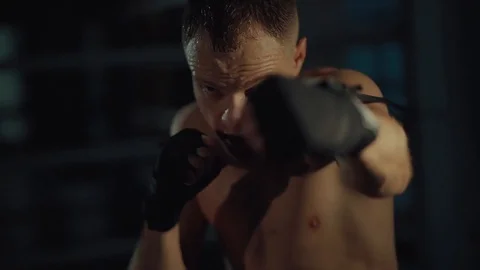 Kickboxer is training his hands with elastic ropes in gym, close-up Stock Footage 98744271