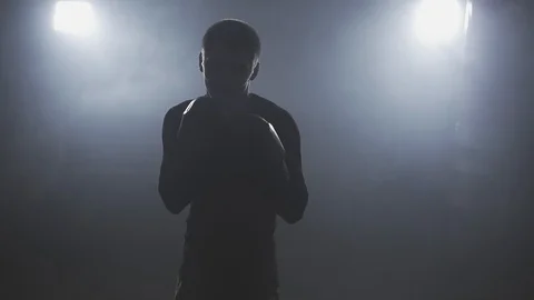 Kickboxer training in low light gym in slow motion. Sportsman boxing in camera Stock Footage 103172458