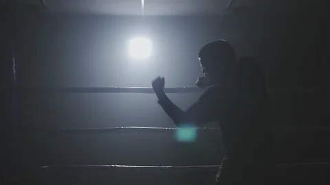 Kickboxer training in low light gym in slow-mo. Sportsman boxing in smoky ring Video stock 109791589