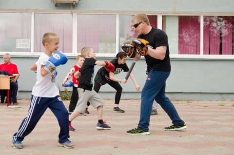 Kickboxing coach will practice punch with boy outdoor in summer Foto stock