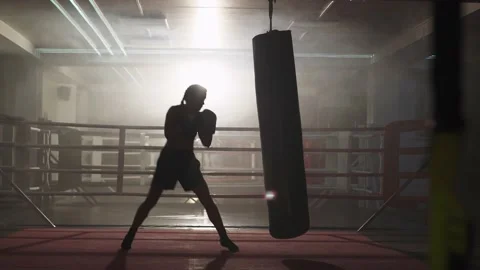 Kickboxing, woman fighter trains his punches, beats a punching bag, training day Stock Footage