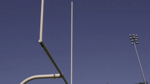 Kicking a football through a field goal post, slow motion football Stock Footage