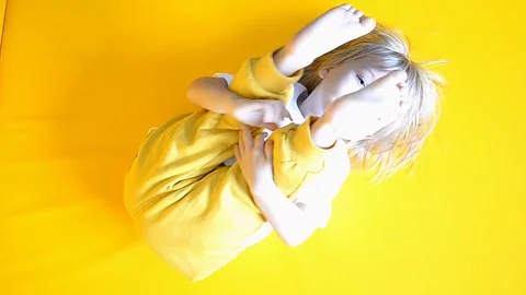 The kid is 2 years old with blonde hair, dressed in a white T-shirt and yellow Stock Footage 251012280