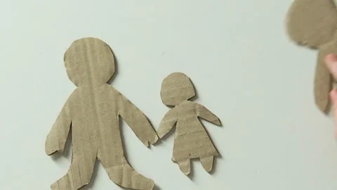 Kid adding figure of mother and toy heart to paper family dreaming about parents Stock Footage 101586847