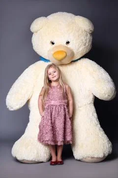 Kid and big white teddy bear Stock Photos
