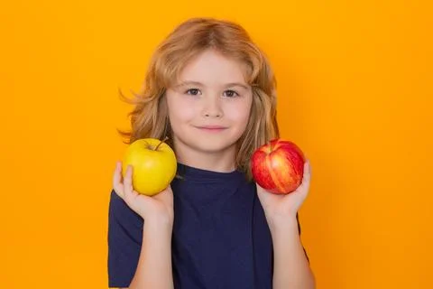 Kid with apple in studio. Studio portrait of cute child hold apple isolated on Stock-Fotos